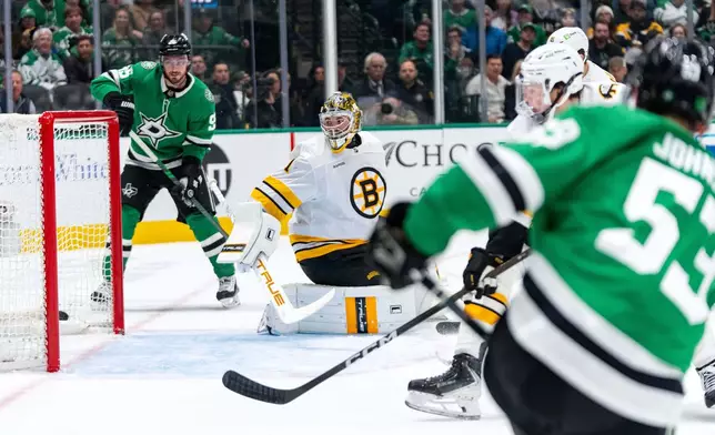Dallas Stars center Wyatt Johnston (53) scores past Boston Bruins goaltender Jeremy Swayman (1) as center Matt Duchene looks on during the first period of an NHL hockey game, Tuesday, Jan. 20, 2026, in Dallas. (AP Photo/Jeffrey McWhorter)