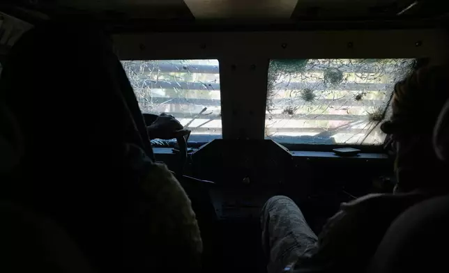 Police in an armored vehicle with a bullet hole-ridden windshield patrol a gang-controlled area of Port-au-Prince, Haiti, Monday, Jan. 19, 2026. (AP Photo/Odelyn Joseph)