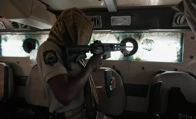Police in an armored vehicle patrol a gang-controlled area of Port-au-Prince, Haiti, Monday, Jan. 19, 2026. (AP Photo/Odelyn Joseph)