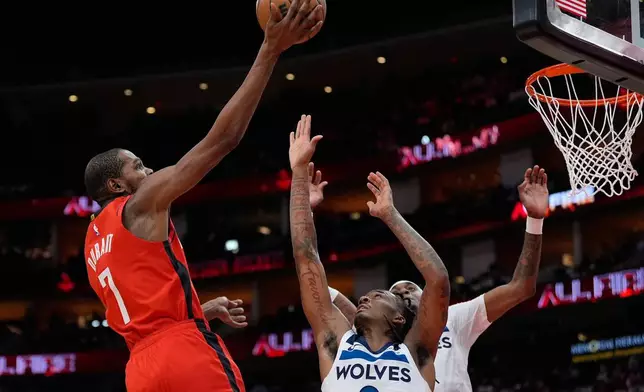 Houston Rockets forward Kevin Durant (7) shoots against Minnesota Timberwolves guard Bones Hyland (8) and forward Jaden McDaniels (3) during the first half of an NBA basketball game in Houston, Friday, Jan. 16, 2026. (AP Photo/Ashley Landis)