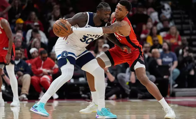 Houston Rockets forward Jabari Smith Jr. (10) defends against Minnesota Timberwolves forward Julius Randle (30) during the first half of an NBA basketball game in Houston, Friday, Jan. 16, 2026. (AP Photo/Ashley Landis)