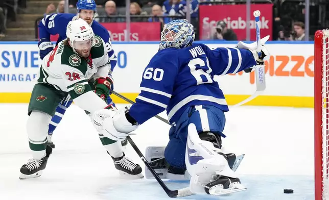 Minnesota Wild forward Ryan Hartman (38) scores past Toronto Maple Leafs goaltender Joseph Woll (60) during first-period NHL hockey game action in Toronto, Monday, Jan. 19, 2026. (Nathan Denette/The Canadian Press via AP)