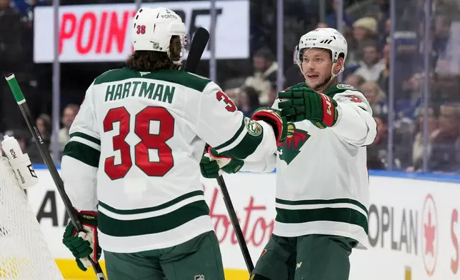 Minnesota Wild forward Vladimir Tarasenko, right, celebrates after his goal with teammate Ryan Hartman (38) during first-period NHL hockey game action against the Toronto Maple Leafs in Toronto, Monday, Jan. 19, 2026. (Nathan Denette/The Canadian Press via AP)