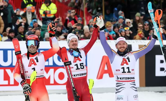 Austria's Manuel Feller, centre, winner of an alpine ski, men's World Cup slalom, poses with second placed Switzerland's Loic Meillard, left, and third placed Germany's Linus Strasser, in Kitzbuehel, Austria, Sunday, Jan. 25, 2026. (AP Photo/Marco Trovati)