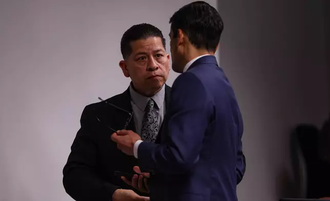 Former Uvalde school district police officer Adrian Gonzales, left, talks to his defense attorney Nico LaHood during a break on the 10th day of his trial at Nueces County Courthouse in Corpus Christi, Texas, Tuesday, Jan. 20, 2026. (Sam Owens/The San Antonio Express-News via AP, Pool)