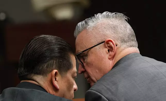 Former Uvalde school district police officer Adrian Gonzales talks with defense attorney Gary Hillier during the seventh day of Gonzales' trial at the Nueces County Courthouse in Corpus Christi, Texas, Wednesday, Jan. 14, 2026. (Sam Owens/The San Antonio Express-News via AP, Pool)