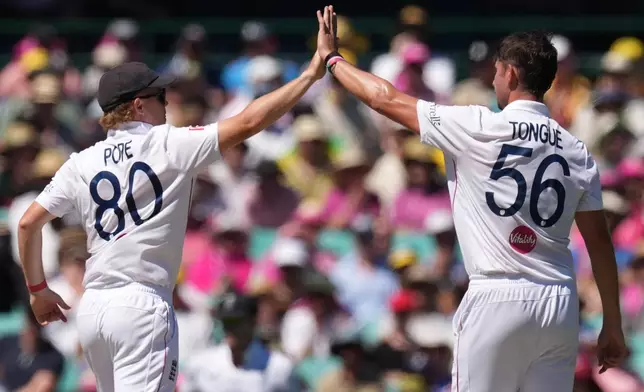 England's Josh Tongue, right, is congratulated by teammate Ollie Pope after dismissing Australia's Mitchell Starc during play on day four of the fifth and final Ashes cricket test between England and Australia in Sydney, Wednesday, Jan. 7, 2026. (AP Photo/Mark Baker)