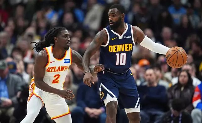 Denver Nuggets guard Tim Hardaway Jr., right, looks to pass the ball as Atlanta Hawks guard Keaton Wallace defends in the first half of an NBA basketball game, Friday, Jan. 9, 2026, in Denver. (AP Photo/David Zalubowski)