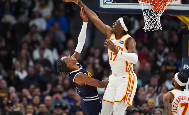 Atlanta Hawks forward Onyeka Okongwu, right, blocks a shot by Denver Nuggets guard Peyton Watson in the first half of an NBA basketball game, Friday, Jan. 9, 2026, in Denver. (AP Photo/David Zalubowski)