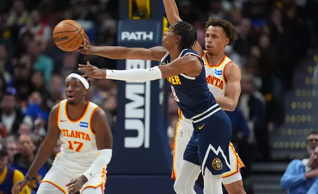 Denver Nuggets guard Peyton Watson, front, passes the ball as Atlanta Hawks guard Dyson Daniels defends in the first half of an NBA basketball game, Friday, Jan. 9, 2026, in Denver. (AP Photo/David Zalubowski)