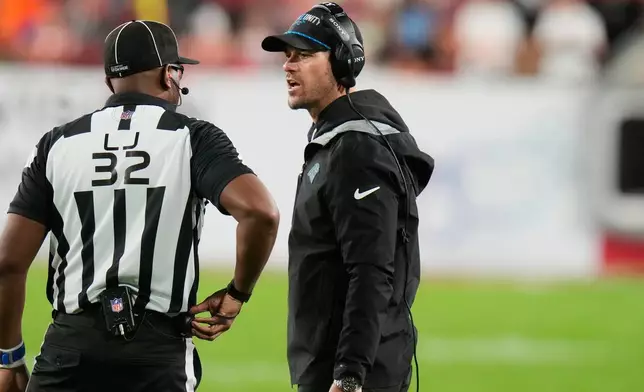 Carolina Panthers head coach Dave Canales talks to line judge Walter Flowers (32) during the second half of an NFL football game against the Tampa Bay Buccaneers Saturday, Jan. 3, 2026, in Tampa, Fla. (AP Photo/Chris O'Meara)