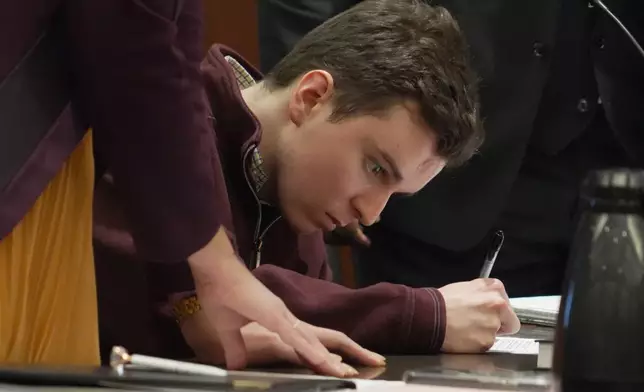 Austin Thompson signs documents pleading guilty to five counts of murder in Wake County Superior Court on Wednesday, Jan. 21, 2026, in Raleigh, N.C. (AP Photo/Allen G. Breed)