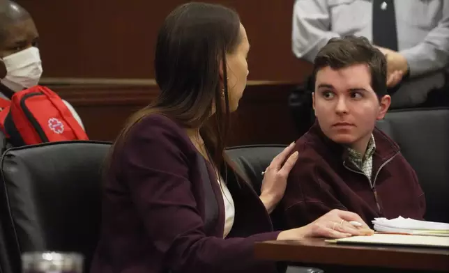 Defense attorney Kellie Mannette touches Austin Thompson's shoulder during a hearing in Wake County Superior Court on Wednesday, Jan. 21, 2026, in Raleigh, N.C. (AP Photo/Allen G. Breed)