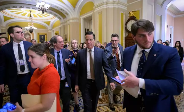 Sen. Bernie Moreno, R-Ohio, center, talks with reporters as he walks through the Ohio Clock Corridor at the Capitol, Tuesday, Jan. 13, 2026, in Washington. (AP Photo/Rod Lamkey, Jr.)