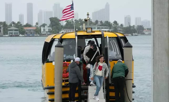 Passengers disembark at the Maurice Gibb Memorial Park, after traveling from the city of Miami, Wednesday, Jan. 21, 2026, in Miami Beach, Fla. (AP Photo/Marta Lavandier)