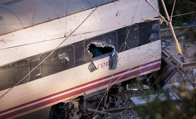 Part of a wrecked train is photographed at the site of a train collision in Adamuz, southern Spain, Monday, Jan. 19, 2026. (AP Photo/Manu Fernandez)