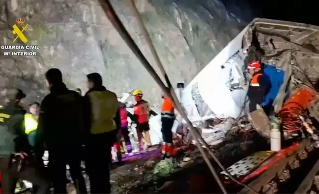 In this grab taken from video provided by Guardia Civil, rescue workers at the scene after a high speed train collision,in Adamuz, Spain, Monday, Jan. 19, 2026. (Guardia Civil via AP)