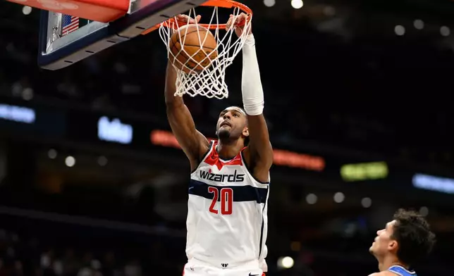 Washington Wizards center Alex Sarr (20) dunks during the first half of an NBA basketball game against the Orlando Magic, Tuesday, Jan. 6, 2026, in Washington. (AP Photo/Nick Wass)