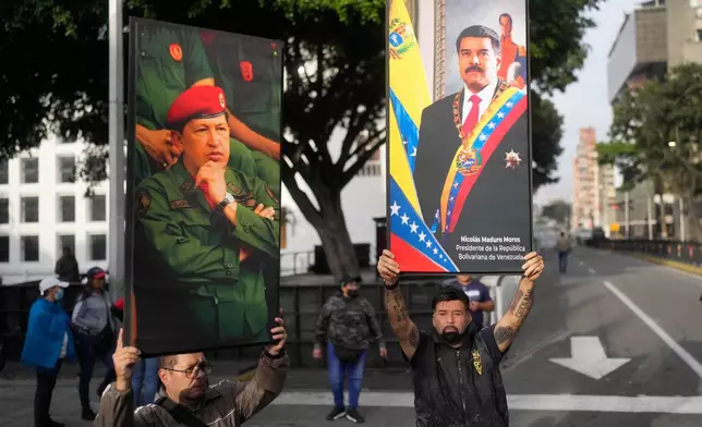 Government supporters display posters of Venezuelan President Nicolás Maduro, right, and former President Hugo Chávez in downtown Caracas, Venezuela, Saturday, Jan. 3, 2026, after U.S. President Donald Trump announced that Maduro had been captured and flown out of the country. (AP Photo/Matias Delacroix)