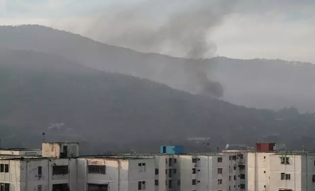Smoke rises from Fort Tiuna, the main military garrison in Caracas, Venezuela, after multiple explosions were heard and aircraft swept through the area, Saturday, Jan. 3, 2026. (AP Photo/Matias Delacroix)
