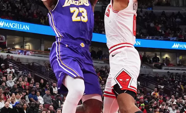 Los Angeles Lakers forward LeBron James, left, shoots against Chicago Bulls guard Coby White during the first half of an NBA basketball game in Chicago, Monday, Jan. 26, 2026. (AP Photo/Nam Y. Huh)