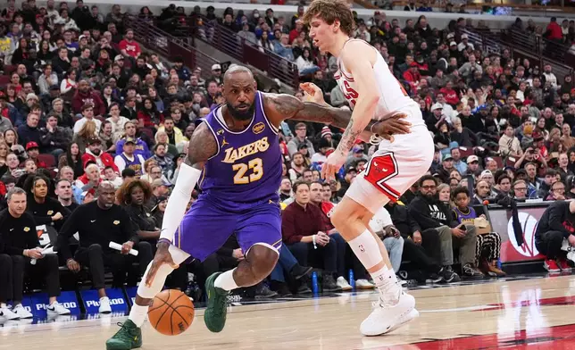 Los Angeles Lakers forward LeBron James, left, drives as Chicago Bulls forward Matas Buzelis guards during the first half of an NBA basketball game in Chicago, Monday, Jan. 26, 2026. (AP Photo/Nam Y. Huh)