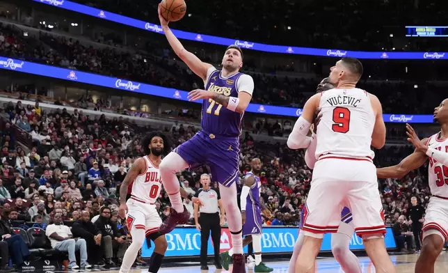 Los Angeles Lakers guard Luka Doncic (77) drives to the basket as Chicago Bulls center Nikola Vucevic (9) watches during the first half of an NBA basketball game in Chicago, Monday, Jan. 26, 2026. (AP Photo/Nam Y. Huh)