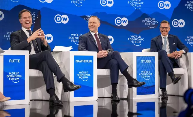 Mark Rutte, left, Secretary-General, North Atlantic Treaty Organization (NATO), Karol Nawrocki, center, President of Poland, and Alexander Stubb, right, President of Finland, speak during a panel discussion during the 56th annual meeting of the World Economic Forum, in Davos, Switzerland, Wednesday, Jan. 21, 2026. (Gian Ehrenzeller/Keystone via AP)
