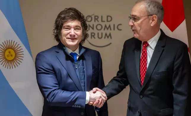 Argentina's President Javier Milei, left, shakes hands with Switzerland's Federal President Guy Parmelin, right, prior to a bilateral meeting on the sideline of the 56th annual meeting of the World Economic Forum, WEF, in Davos, Switzerland, Wednesday, Jan. 21, 2026. (Laurent Gillieron/Keystone pool via AP)