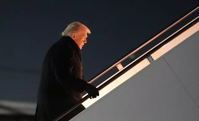 President Donald Trump boards Air Force One for a trip to attend the World Economic Form in Davos, Tuesday, Jan. 20, 2026, at Joint Base Andrews, Md. (AP Photo/Evan Vucci)