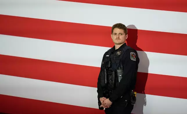 A Clive, Iowa, Police Officer looks at the crowd before President Donald Trump speaks during a rally, Tuesday, Jan. 27, 2026, in Clive, Iowa. (AP Photo/Charlie Neibergall)