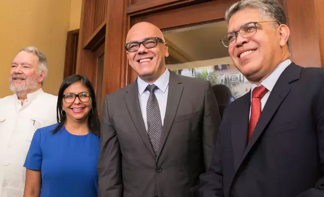 FILE - Constitutional Assembly President Delcy Rodriguez, and her brother, Minister of Communications Jorge Rodriguez, center right, flanked by diplomat Roy Chaderton, left, and former Vice President Elias Jaua, pose for a photo at the Ministry of Foreign Affairs in Santo Domingo, Dominican Republic, Dec. 1, 2017. (AP Photo/Tatiana Fernandez, File)
