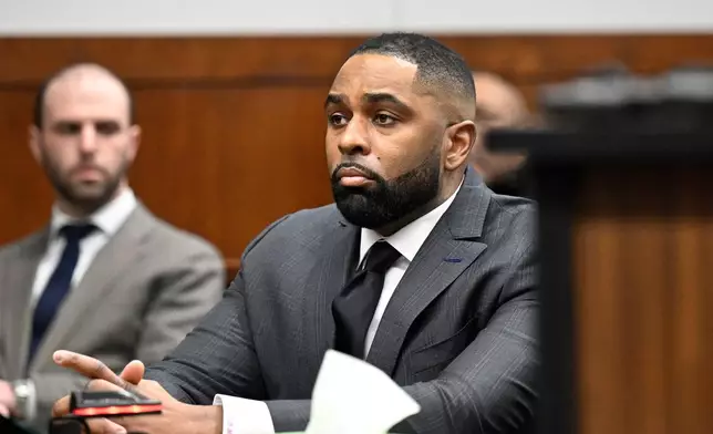 Former Michigan football coach Sherrone Moore, center, appears in the courtroom, Thursday, Jan. 22, 2026, in Ann Arbor, Mich. (AP Photo/Jose Juarez)