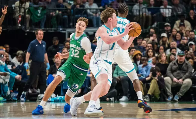 Charlotte Hornets guard Kon Knueppel (7) moves the ball away from Dallas Mavericks forward Cooper Flagg (32) during an NBA basketball game, Thursday, Jan. 29, 2026, in Dallas. (AP Photo/Jessica Tobias)