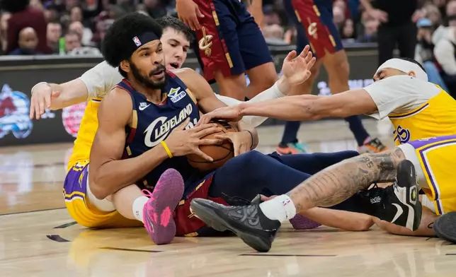 Cleveland Cavaliers center Jarrett Allen, center, fights for control of the ball with Los Angeles Lakers forward Jake LaRavia, left, and center Jaxson Hayes, right, in the first half of an NBA basketball game in Cleveland, Wednesday, Jan. 28, 2026. (AP Photo/Sue Ogrocki)