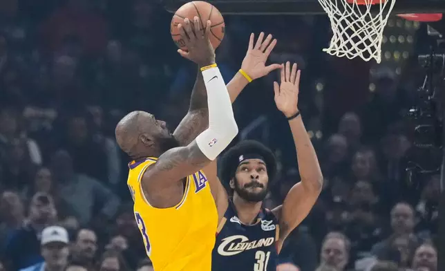 Los Angeles Lakers forward LeBron James left, shoots over Cleveland Cavaliers center Jarrett Allen (31) in the first half of an NBA basketball game in Cleveland, Wednesday, Jan. 28, 2026. (AP Photo/Sue Ogrocki)