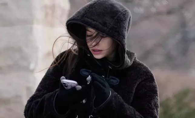 A pedestrian bundles up as she crosses a street during a cold weather day in Evanston, Ill., Thursday, Jan. 22, 2026. (AP Photo/Nam Y. Huh)