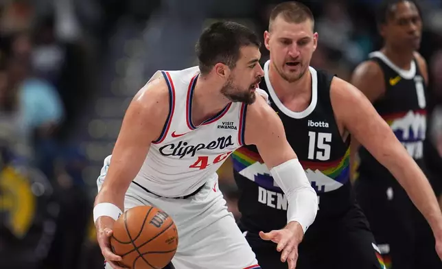 Los Angeles Clippers center Ivica Zubac, left, looks to pass the ball as Denver Nuggets center Nikola Jokić (15) defends in the first half of an NBA basketball game Friday, Jan. 30, 2026, in Denver. (AP Photo/David Zalubowski)