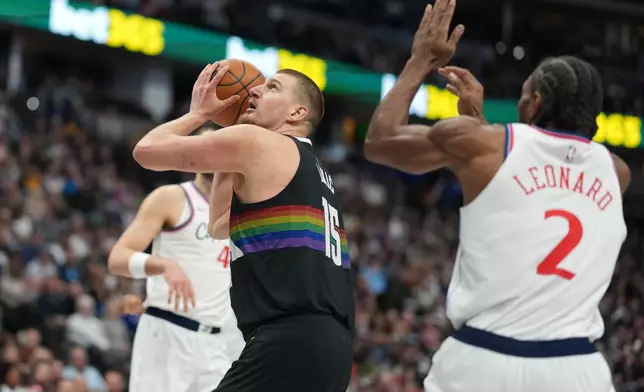 Denver Nuggets center Nikola Jokić (15) goes up for a basket as Los Angeles Clippers forward Kawhi Leonard (2) defends in the first half of an NBA basketball game Friday, Jan. 30, 2026, in Denver. (AP Photo/David Zalubowski)