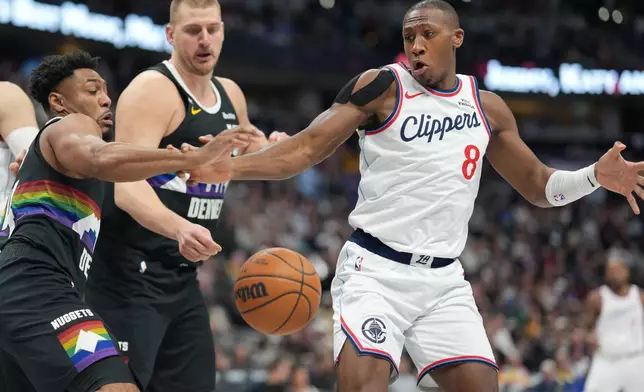 From left to right, Denver Nuggets guard Jalen Pickett and center Nikola Jokić pursue the ball with Los Angeles Clippers guard Kris Dunn in the second half of an NBA basketball game Friday, Jan. 30, 2026, in Denver. (AP Photo/David Zalubowski)