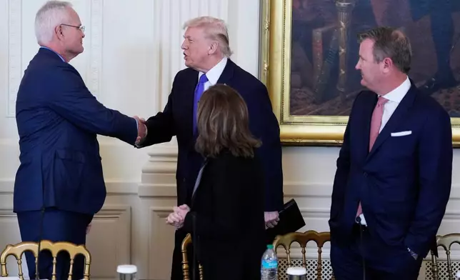 President Donald Trump speaks with Chief Executive Officer and Chairman of ExxonMobil Darren Woods, left, while Chairman, President and Chief Executive Officer of Marathon Petroleum Maryann Mannen, right, and Tallgrass Energy President and Chief Executive Officer Matt Sheehy, far right, look on during a meeting with oil executives in the East Room of the White House, Friday, Jan. 9, 2026, in Washington. (AP Photo/Alex Brandon)