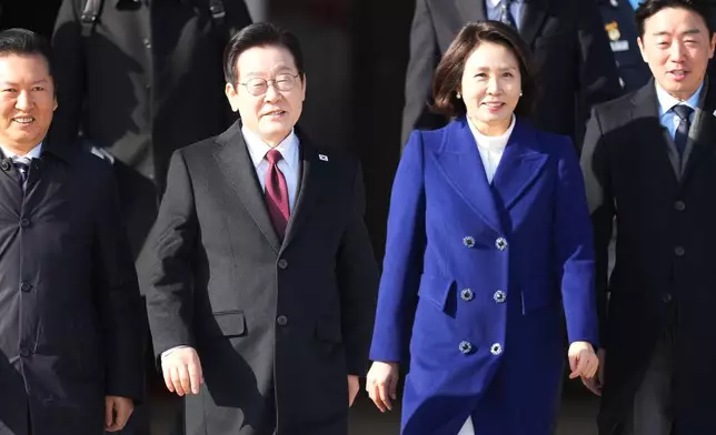 South Korean President Lee Jae Myung, center left, and his wife Kim Hea Kyung arrive to depart for China at the Seoul airport in Seongnam, South Korea, Sunday, Jan. 4, 2026. (AP Photo/Lee Jin-man)