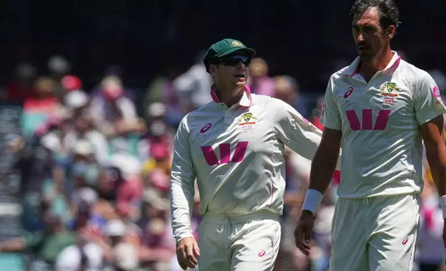 Australia's captain Steve Smith, left, talks to teammate Mitchell Starc during play on day two of the fifth and final Ashes cricket test between England and Australia in Sydney, Monday, Jan. 5, 2026. (AP Photo/Mark Baker)