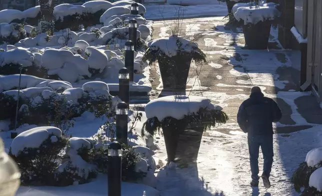 A person walks through the cold on the Campau Promenade in Grand Rapids, Mich. on Friday, Jan. 23, 2026. (Joel Bissell/Kalamazoo Gazette via AP)