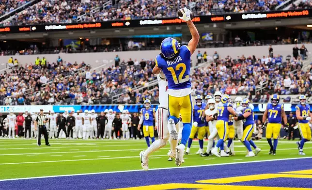 Los Angeles Rams wide receiver Puka Nacua (12) catches a touchdown while defended by Arizona Cardinals cornerback Denzel Burke (29) during the first half of an NFL football game, Sunday, Jan. 4, 2026, in Inglewood, Calif. (AP Photo/Mark J. Terrill)