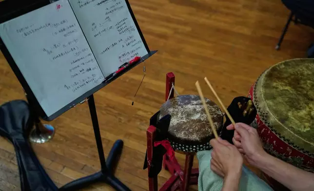A drummer plays a traditional drum during a rehearsal for a Peking Opera show in Beijing, China, Friday, Sept. 5, 2025. (AP Photo/Mahesh Kumar A.)