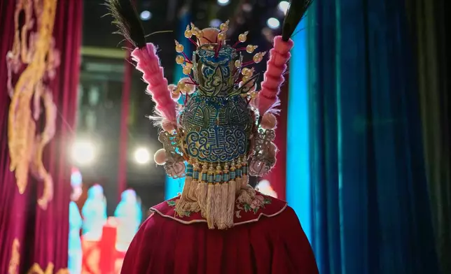A Peking Opera actress applies makeup backstage before a show in Beijing, China, Sunday, Sept. 7, 2025. (AP Photo/Mahesh Kumar A.)