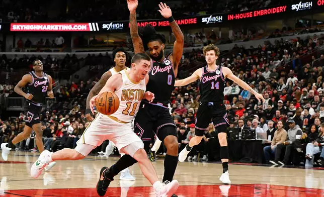 Boston Celtics guard Payton Pritchard (11) drives against Chicago Bulls guard Coby White (0) during the first half of an NBA basketball game Monday, Jan. 24, 2026, in Chicago. (AP Photo/Matt Marton)
