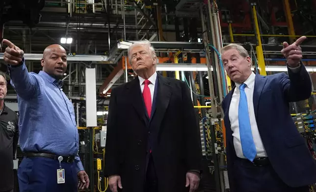 President Donald Trump listens to Corey Williams, Ford River Rouge Plant Manager, left, and Bill Ford, Executive Chairman of Ford, during a tour of the Ford River Rogue complex, Tuesday, Jan. 13, 2026, in Dearborn, Mich. (AP Photo/Evan Vucci)