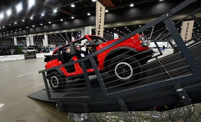 FILE - Guests are given a ride in a Bronco on a track at the Detroit Auto Show, Friday, Jan. 10, 2025, in Detroit. (AP Photo/Jose Juarez, file)